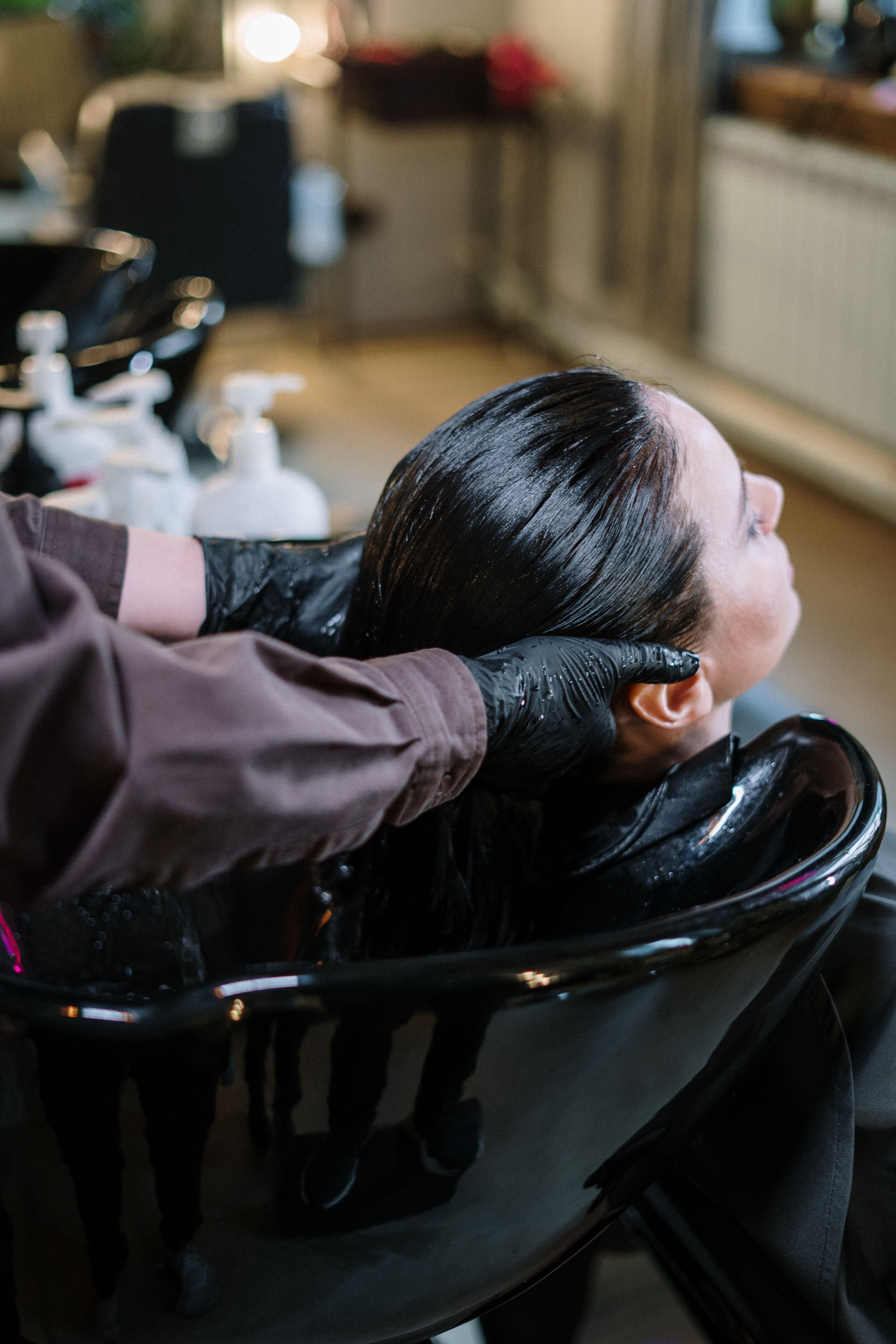 Client having her hair washed at a salon basin