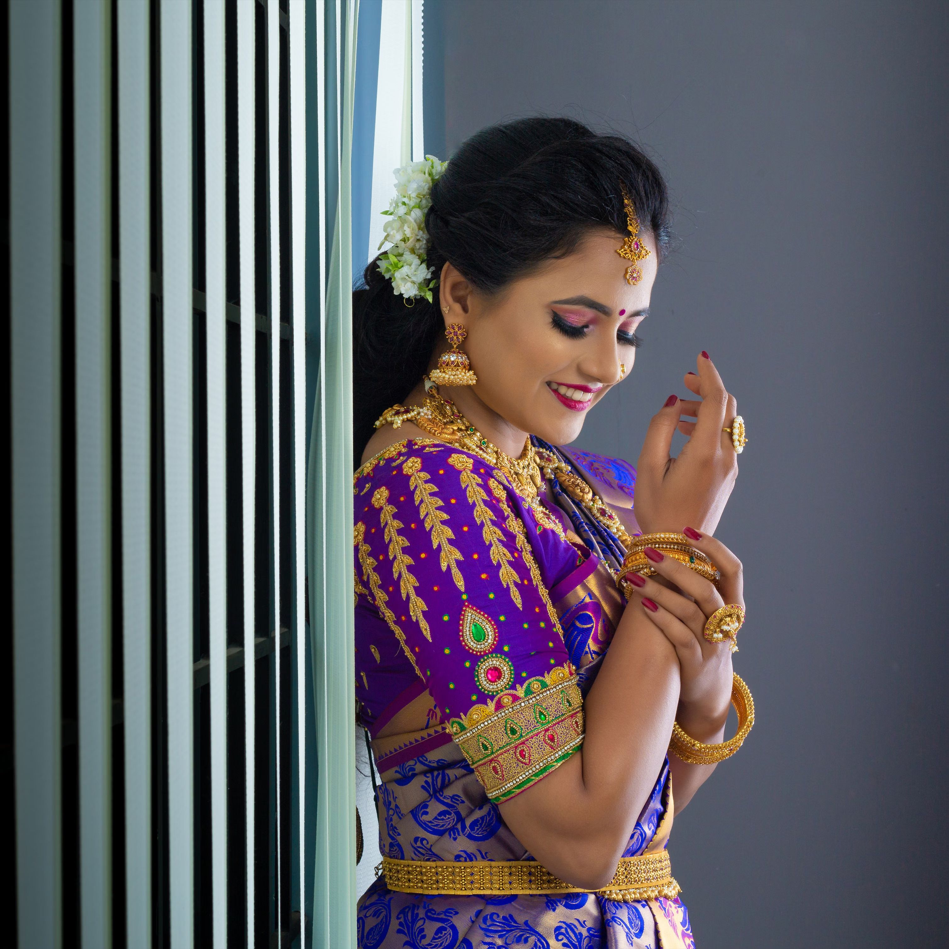 Bride in a purple sari with traditional jewellery