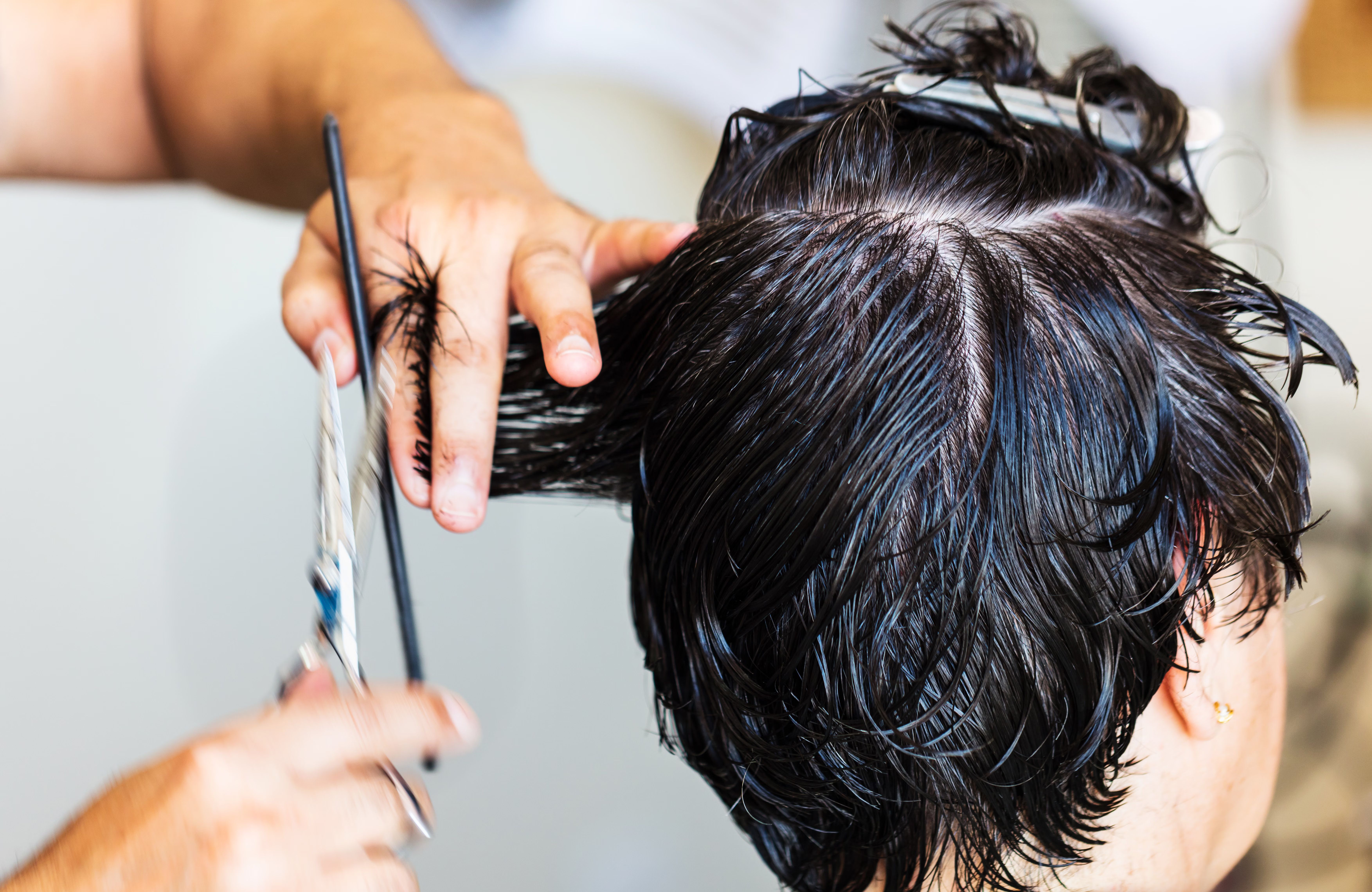 Stylist cutting a client’s short dark hair