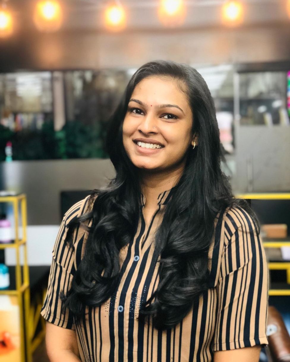 Smiling client with long, softly curled layered hair