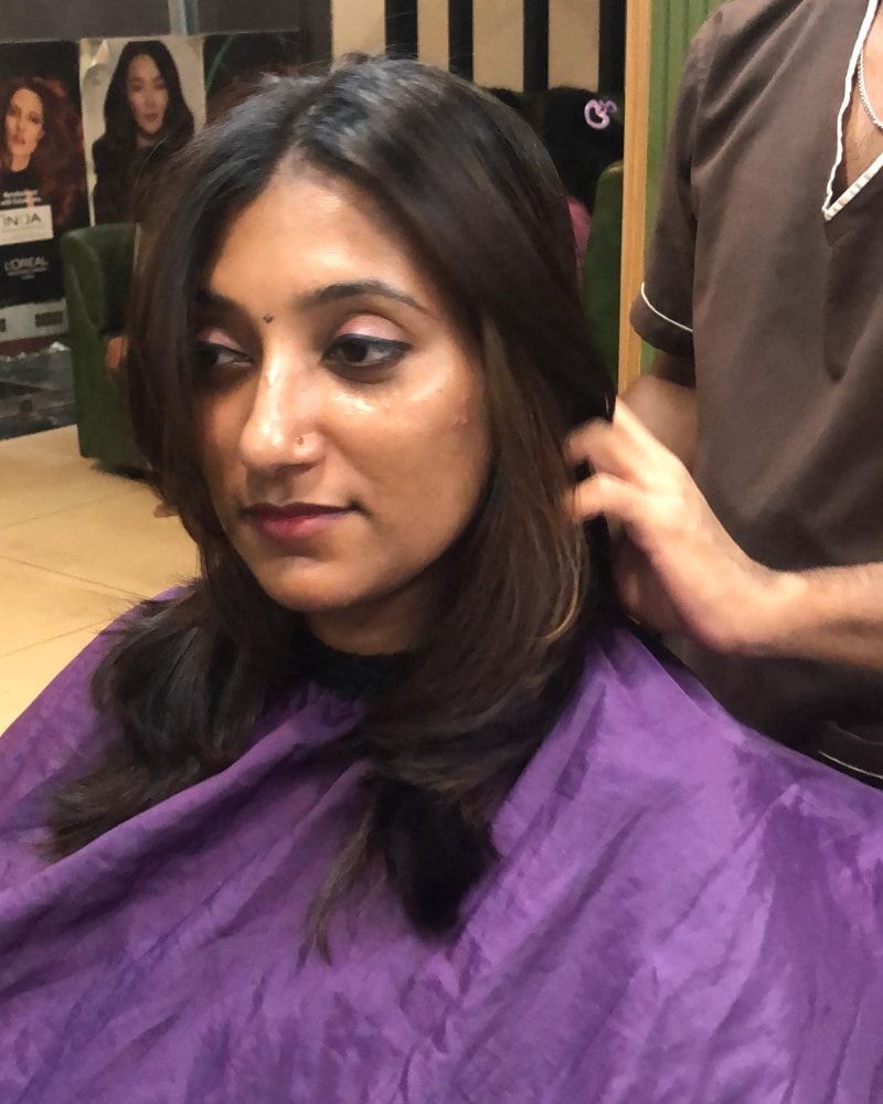 Stylist finishing a layered haircut with highlights
