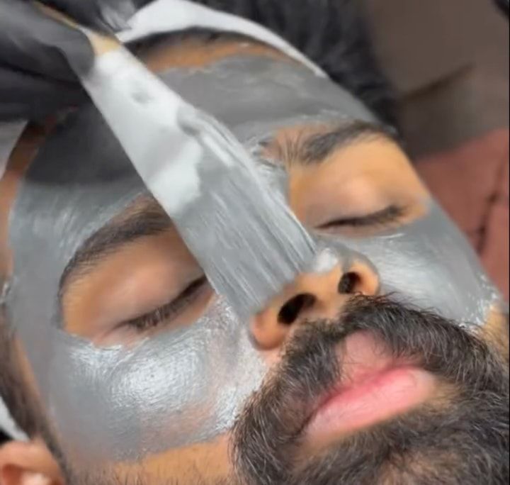 Therapist brushing a de-tan mask onto a client’s face