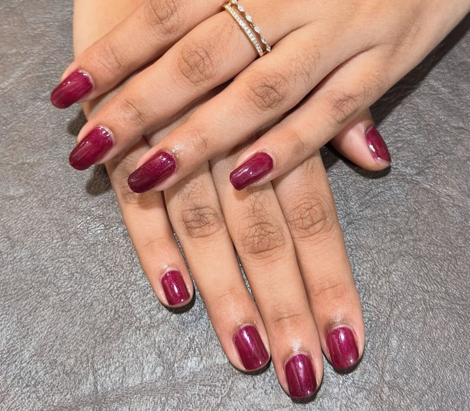 Hands with glossy ruby red gel nails